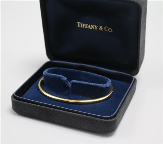 A Tiffany & Co 18ct gold bangle, with Tiffany & Co boxes.